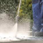 Pavement Power Cleaning. Pressure Washer in Action. Closeup Photo.