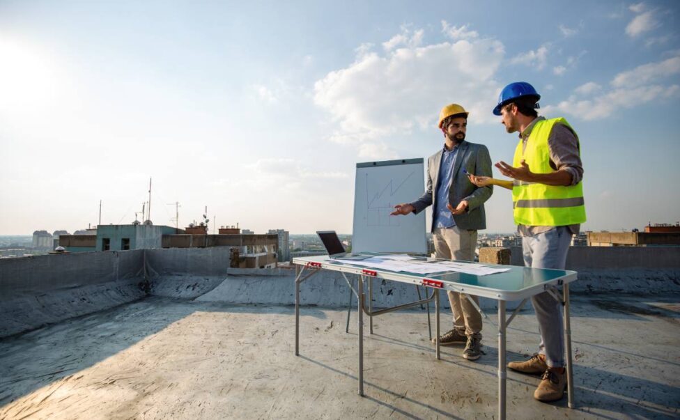 Team of architects and engineers people in group on construciton site check documents