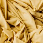 A closeup shot of a vibrant yellow fabric, perfect for use as a background in a variety of projects