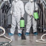 Start up, business and quarantine. Guys in protective suits and masks work at factory and Disinfected Cleaning Services